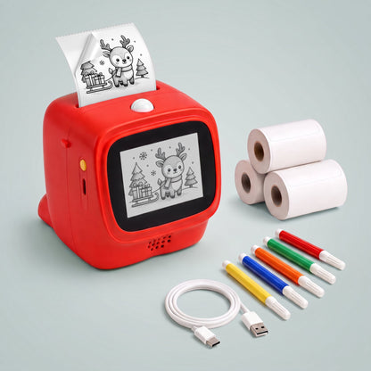 red talkbox AI voice sticker printer with a reindeer drawing printed on continuous peel-off label tape coming out of the top and on its screen, beside three label rolls, five markers and a USB cable